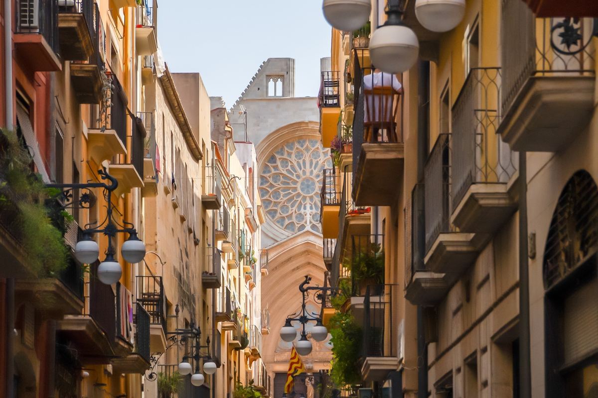 Carrer Major con balcones, faroles y el rosetón de la Catedral al fondo.