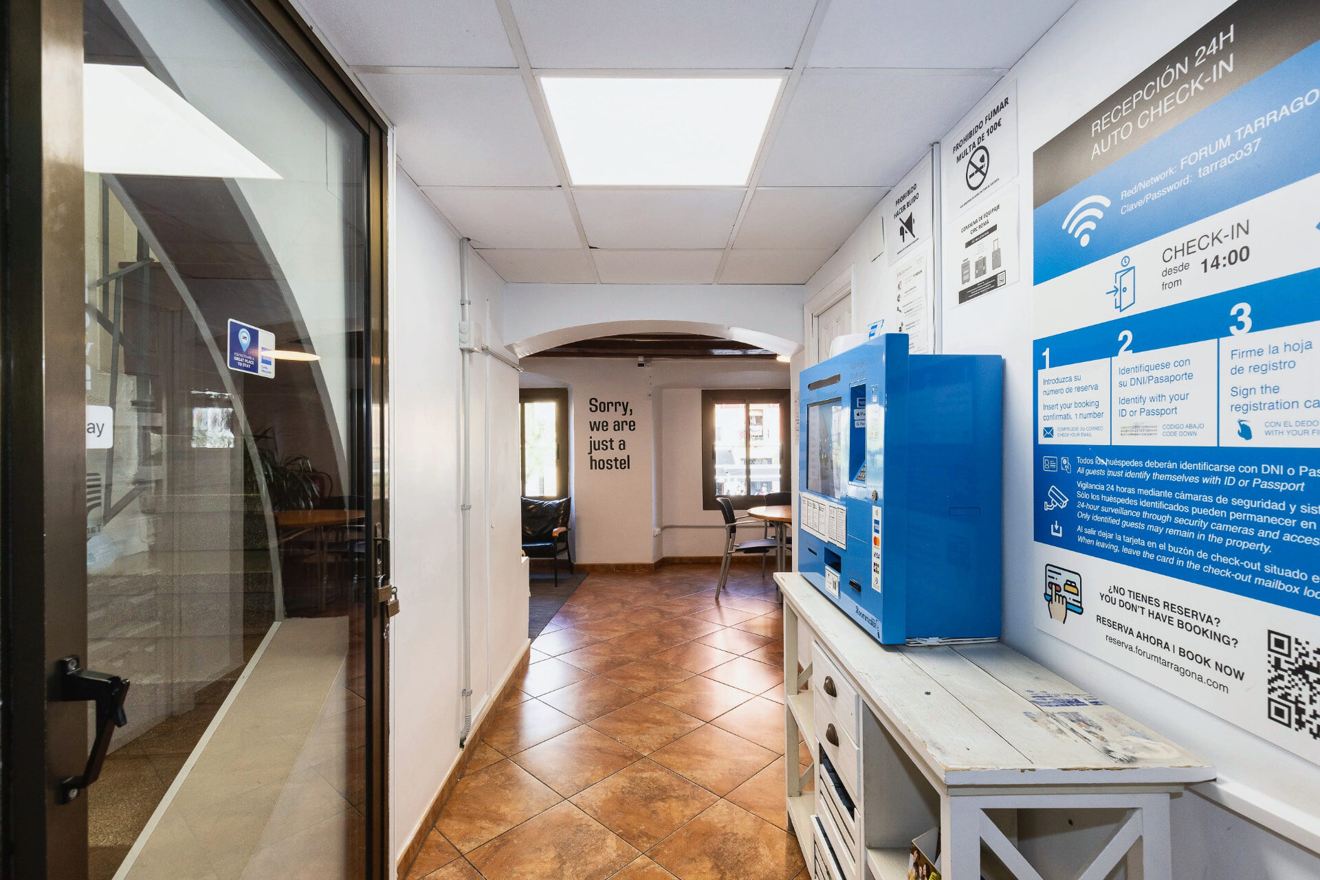 Cajero automático de llaves azul en el pasillo de entrada del hostal.