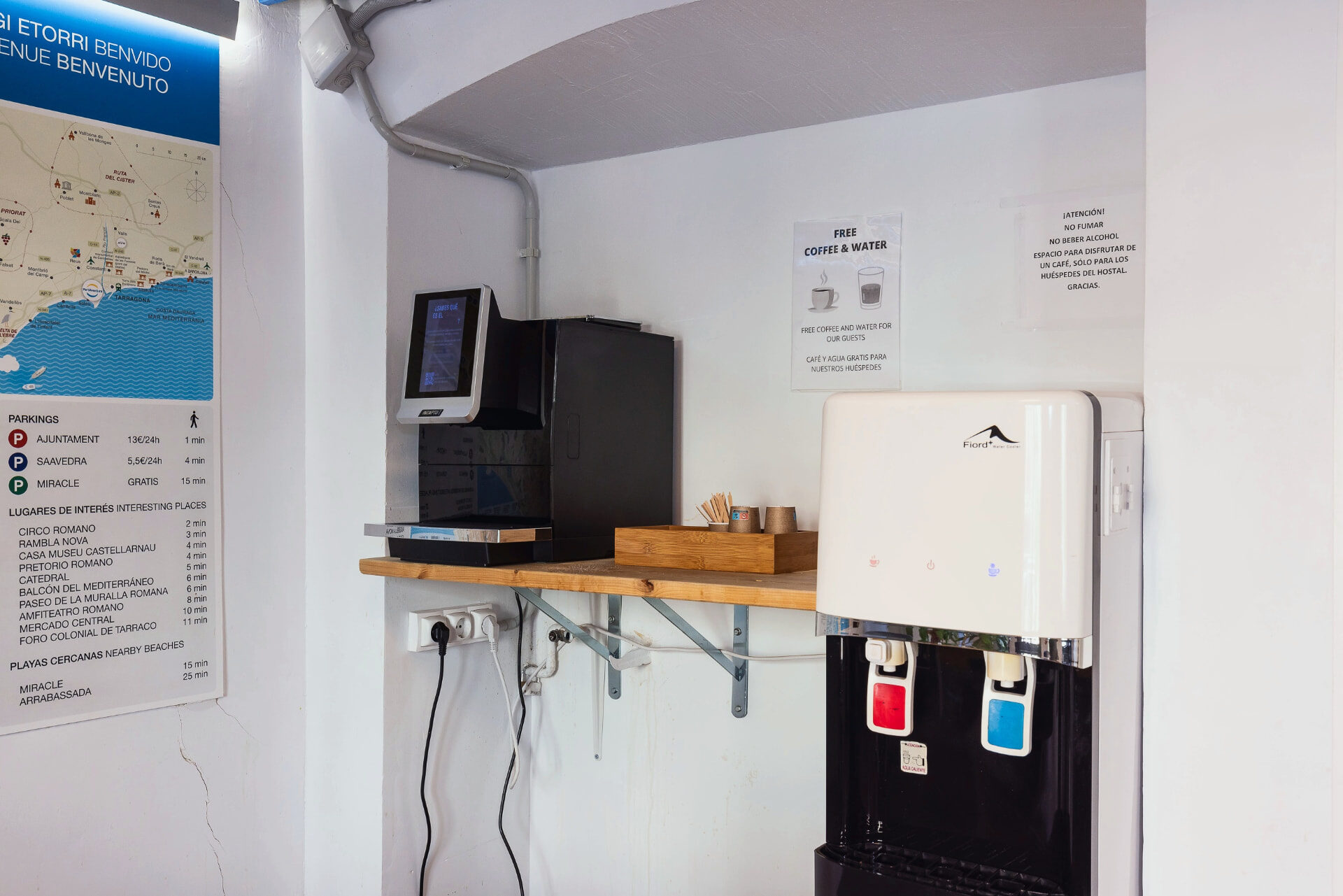 Rincón de café y dispensador de agua gratuita en la zona común del hostal.