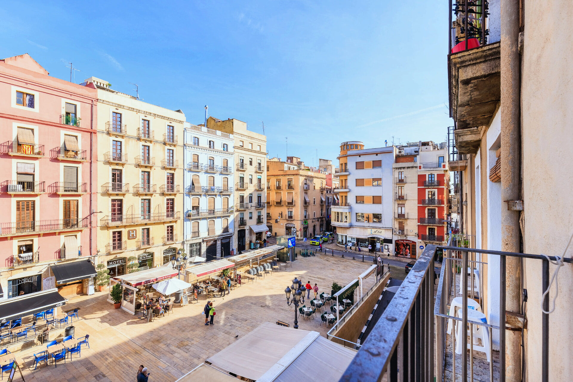 Vista de la Plaça de la Font de Tarragona desde un balcón del Hostal Forum, con los toldos de las terrazas y el Ayuntamiento al fondo.